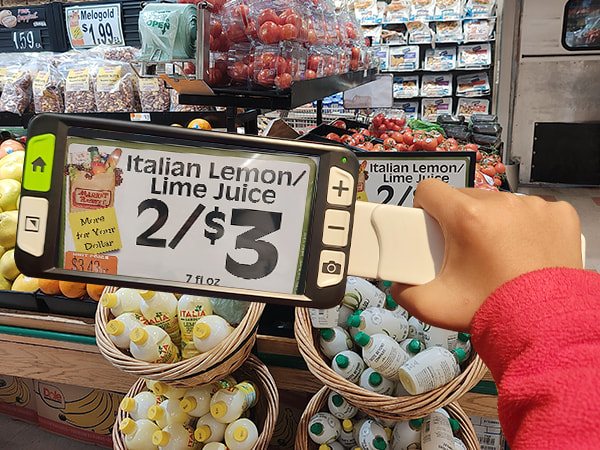 LUNA 6 handheld electronic magnifier helping low-vision user read price tag during Thanksgiving shopping
